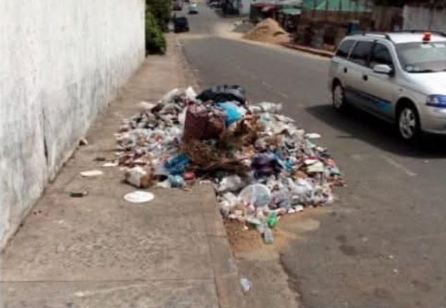 Rubbish dumped on a pavement beside a road, reported with the TrashDrop app